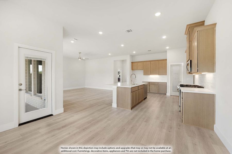 Open-concept kitchen and living area with light wood cabinets, center island, and light hardwood floors Open-concept kitchen and living area with light wood cabinets, center island, and light hardwood floors
