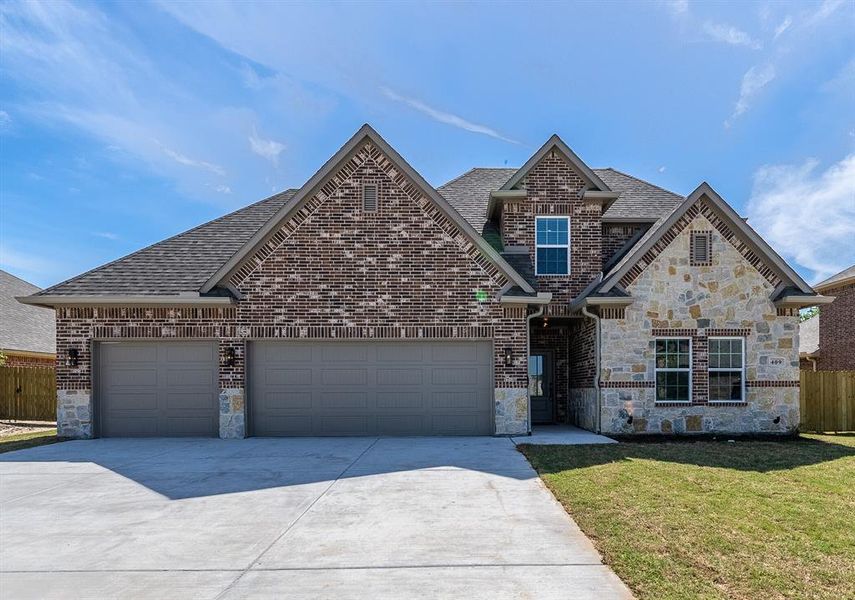 View of front of home with stone siding, a garage, driveway, and roof with shingles View of front of home with stone siding, a garage, driveway, and roof with shingles
