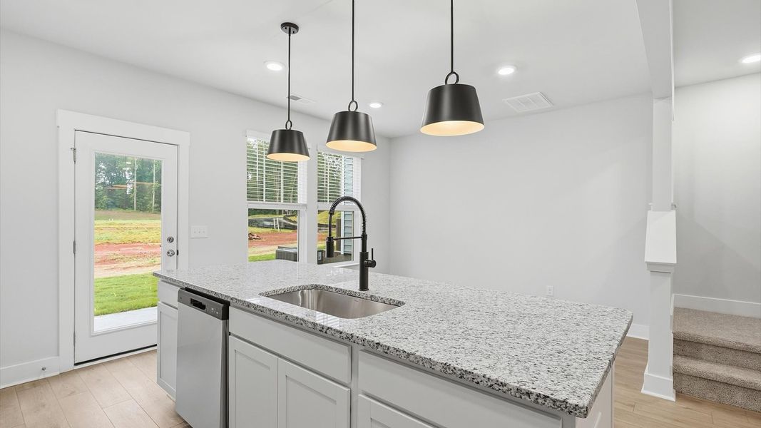 Exclusive kitchen design with large island, pendant lights, and tasteful finishes throughout by DRB Homes Exclusive kitchen design with large island, pendant lights, and tasteful finishes throughout by DRB Homes