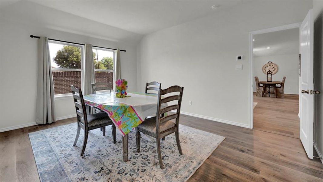 Dining area featuring lofted ceiling and wood finished floors