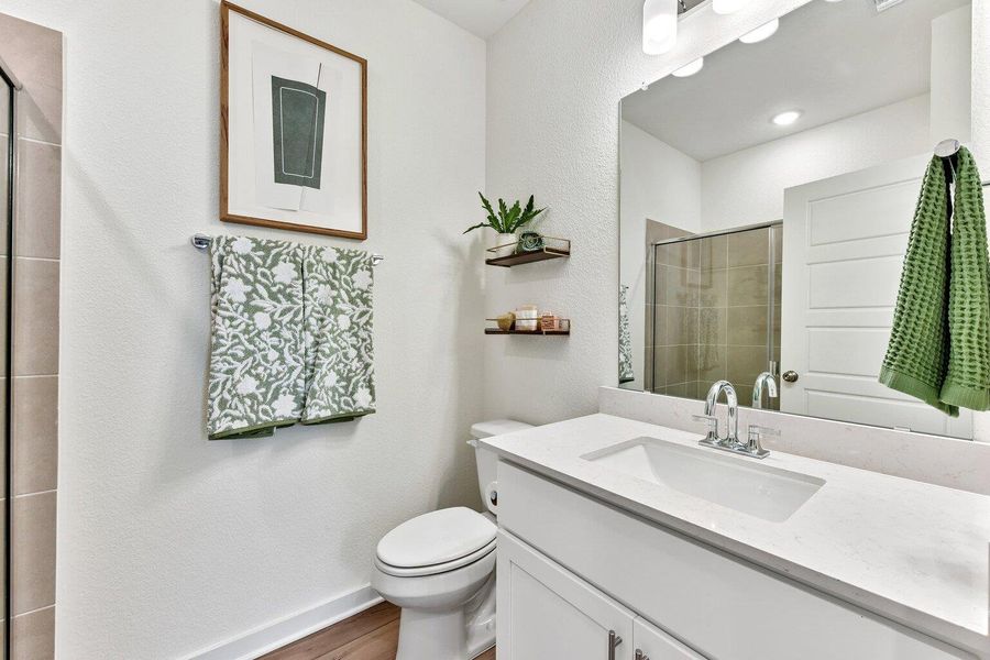 An elegant bathroom features a white vanity topped with polished stone counters and sleek cabinetry. An elegant bathroom features a white vanity topped with polished stone counters and sleek cabinetry.