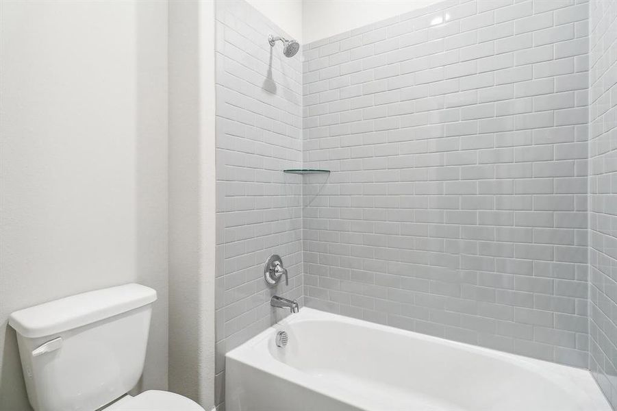 Bathroom featuring toilet and tiled shower / bath