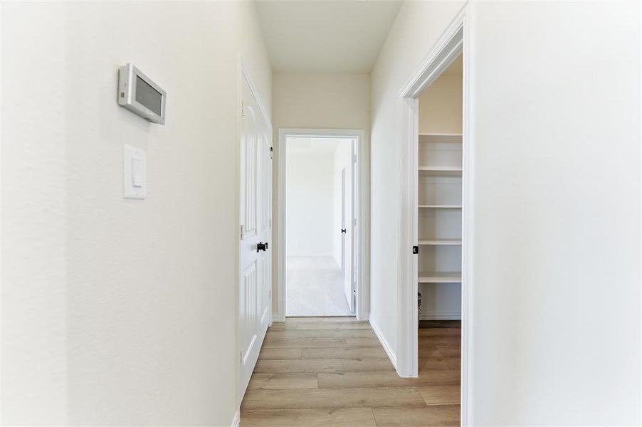 Corridor featuring light wood finished floors and baseboards