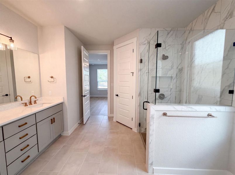Luxurious bathroom offering a dual-sink vanity and a spacious glass-enclosed shower. Luxurious bathroom offering a dual-sink vanity and a spacious glass-enclosed shower.