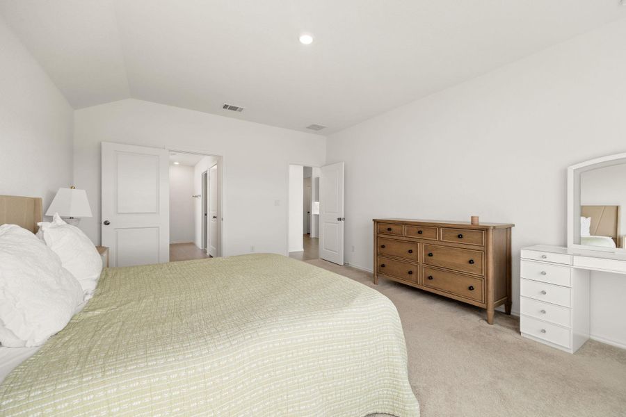 Well-lit and tranquil, this bedroom provides a serene retreat with soft carpeting and private access to additional spaces.