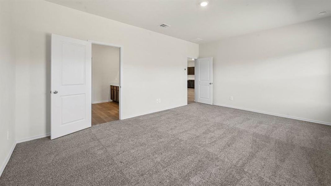 Spacious room with plush gray carpeting, crisp white walls, and recessed lighting