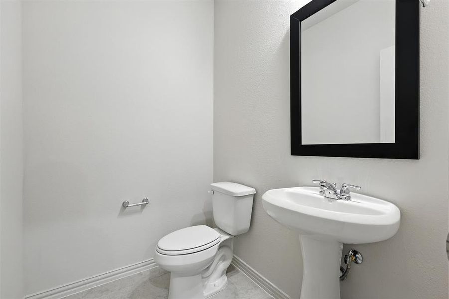 Half bathroom featuring toilet and baseboards Half bathroom featuring toilet and baseboards