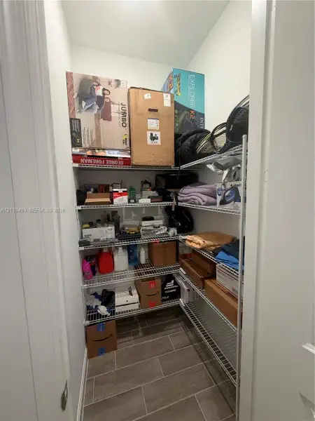 Storage area featuring multi-tier wire shelving and tile flooring