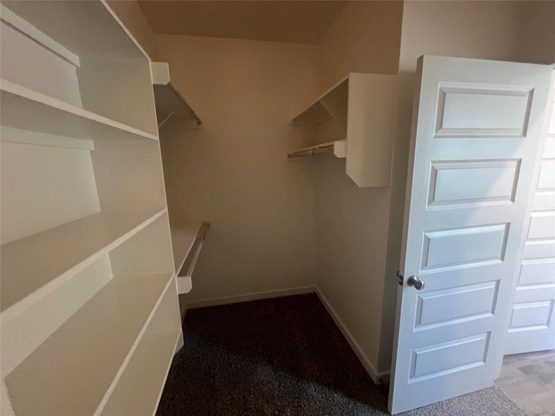 Ample shelving and hanging space defines this thoughtfully organized walk-in closet.
