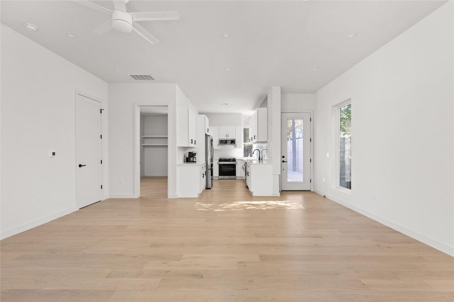 Unfurnished living room with light wood finished floors and a ceiling fan