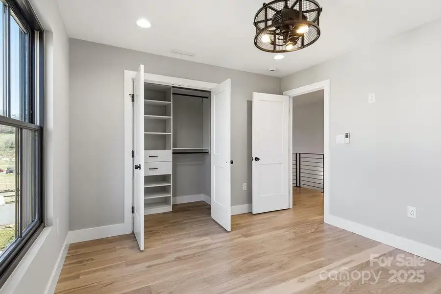 Sunny secondary bedroom with generous closet space and serene views