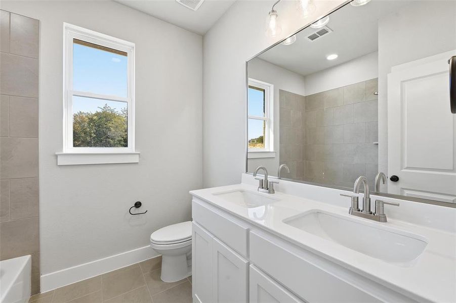 Bathroom featuring double vanity and light tile patterned flooring Bathroom featuring double vanity and light tile patterned flooring