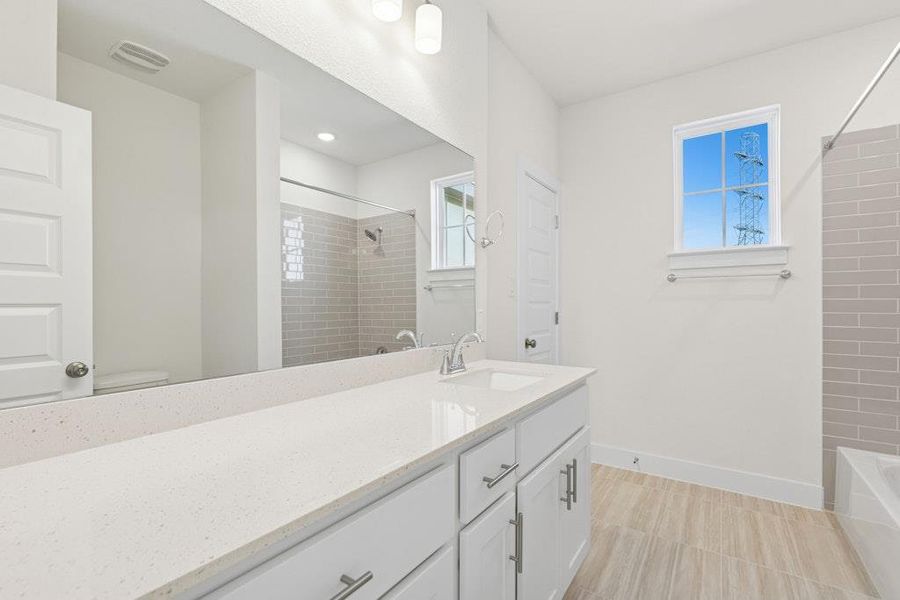 Bathroom featuring vanity, shower / tub combination, and light tile patterned flooring Bathroom featuring vanity, shower / tub combination, and light tile patterned flooring
