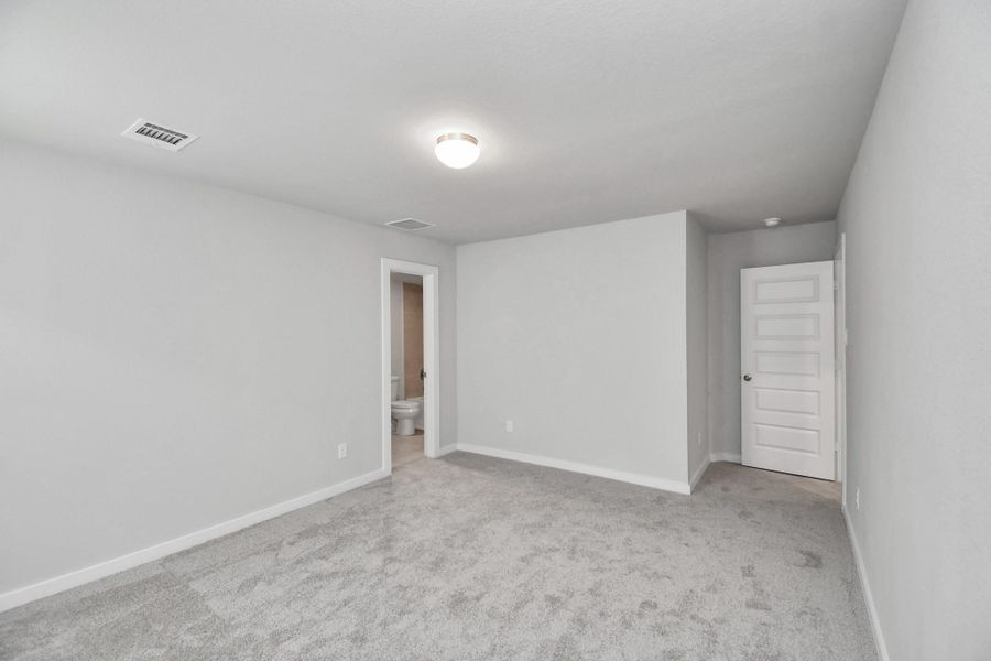 Secondary bedroom features plush carpeting, large windows that let in plenty of natural light, bright paint, and spacious closets.
