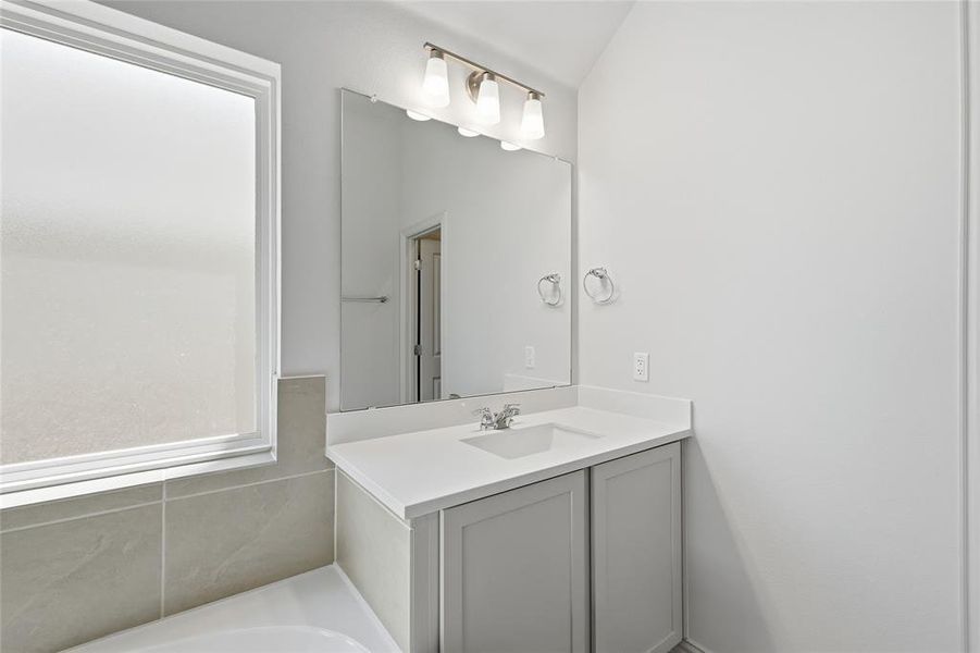 Full bathroom with vanity and a garden tub