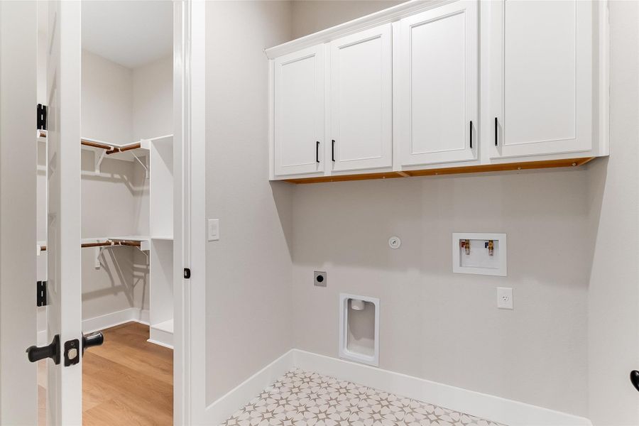 Laundry area featuring electric dryer hookup, hookup for a washing machine, cabinet space, gas dryer hookup, and light flooring