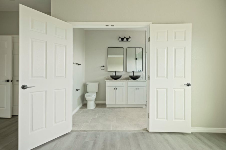 Bathroom with double vanity and light wood finished floors