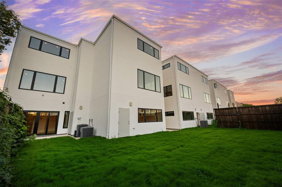 Back of property at dusk featuring stucco siding