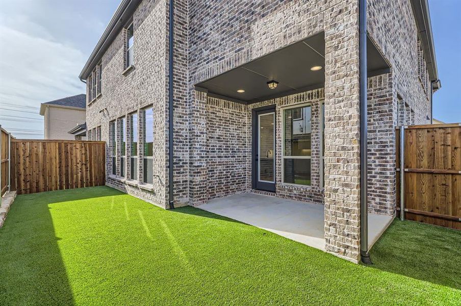 Rear view of property with a patio area and a yard