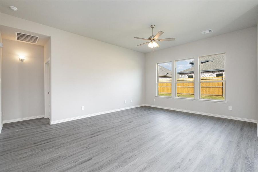 Empty room with hardwood / wood-style floors and ceiling fan