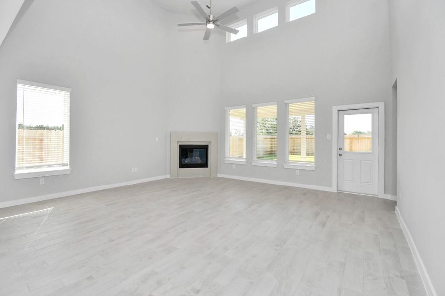 Welcome family and guests to your charming living room! With its high ceilings, recessed lighting, ceiling fan, custom paint, beautiful flooring, and large windows that let in abundant natural light, this room is perfect for gatherings. Sample photo of completed home with similar floor plan. Actual colors and selections may vary. Welcome family and guests to your charming living room! With its high ceilings, recessed lighting, ceiling fan, custom paint, beautiful flooring, and large windows that let in abundant natural light, this room is perfect for gatherings. Sample photo of completed home with similar floor plan. Actual colors and selections may vary.