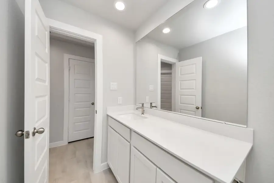 The secondary bath boasts stylish tile flooring, a bath/shower combo with a sleek tile surround, light wood cabinets, and a stunning light countertop. Sample photo of completed home with similar floor plan. Actual colors and selections may vary. The secondary bath boasts stylish tile flooring, a bath/shower combo with a sleek tile surround, light wood cabinets, and a stunning light countertop. Sample photo of completed home with similar floor plan. Actual colors and selections may vary.