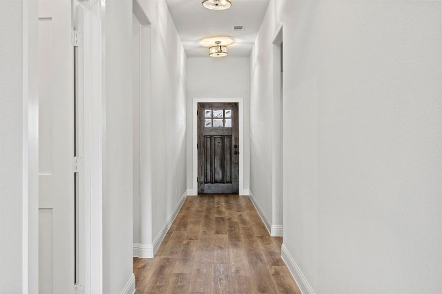 Doorway to outside with wood finished floors and baseboards