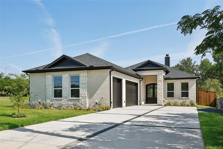 View of front of home with a garage and a front lawn