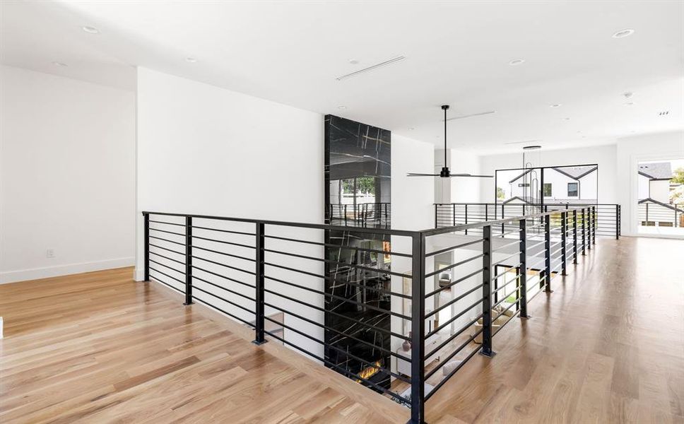 Hallway featuring wood finished floors, recessed lighting, and an upstairs landing Hallway featuring wood finished floors, recessed lighting, and an upstairs landing