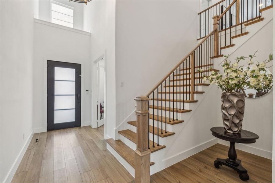 Foyer with hardwood / wood-style flooring and a towering ceiling