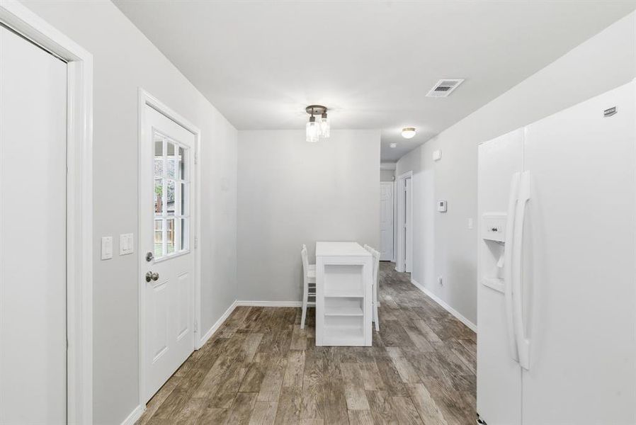 Unfurnished dining area featuring light wood-style floors and baseboards Unfurnished dining area featuring light wood-style floors and baseboards