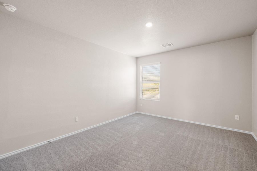 Spare room featuring carpet flooring and baseboards