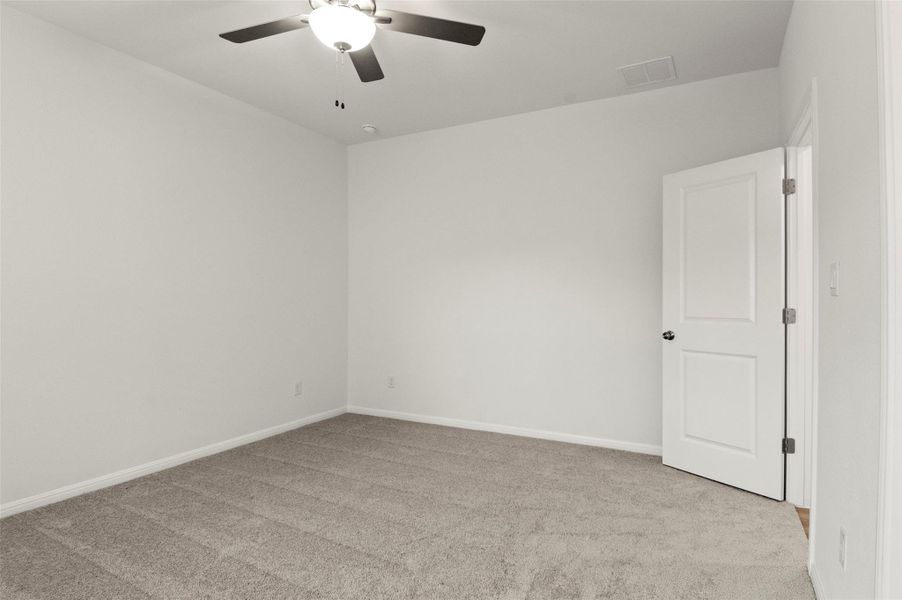 Carpeted empty room featuring a ceiling fan and baseboards Carpeted empty room featuring a ceiling fan and baseboards