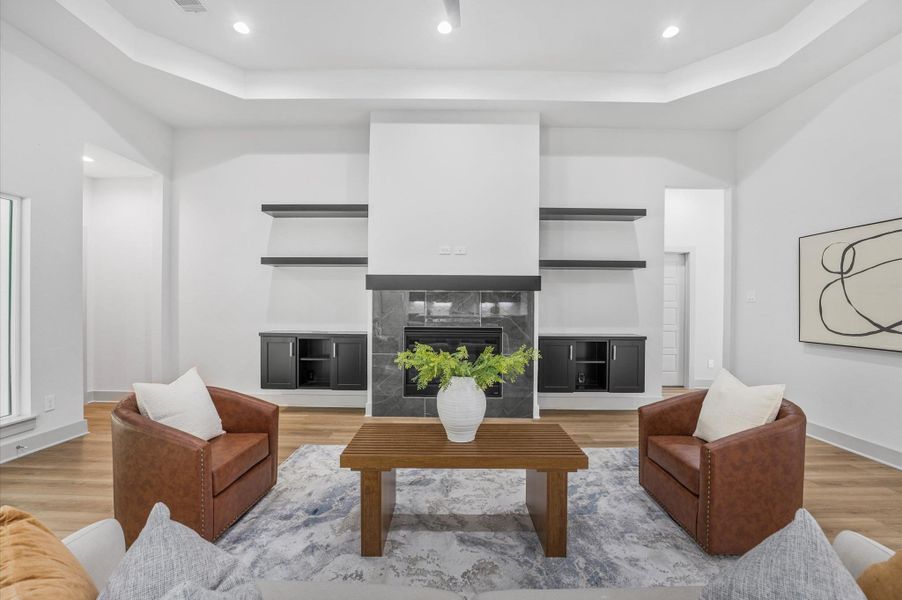 This spacious living room features a modern fireplace with sleek black shelving on either side. The room is bright with high ceilings and recessed lighting. It includes a cozy seating area with two leather chairs and a stylish wooden coffee table. The neutral palette and minimalist decor create a welcoming and elegant atmosphere. This spacious living room features a modern fireplace with sleek black shelving on either side. The room is bright with high ceilings and recessed lighting. It includes a cozy seating area with two leather chairs and a stylish wooden coffee table. The neutral palette and minimalist decor create a welcoming and elegant atmosphere.