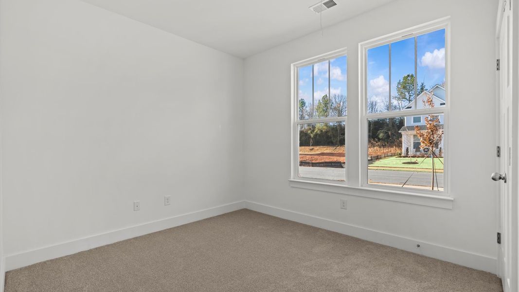 Superior comfort in this light-filled bedroom with plush carpeting and thoughtfully placed large windows