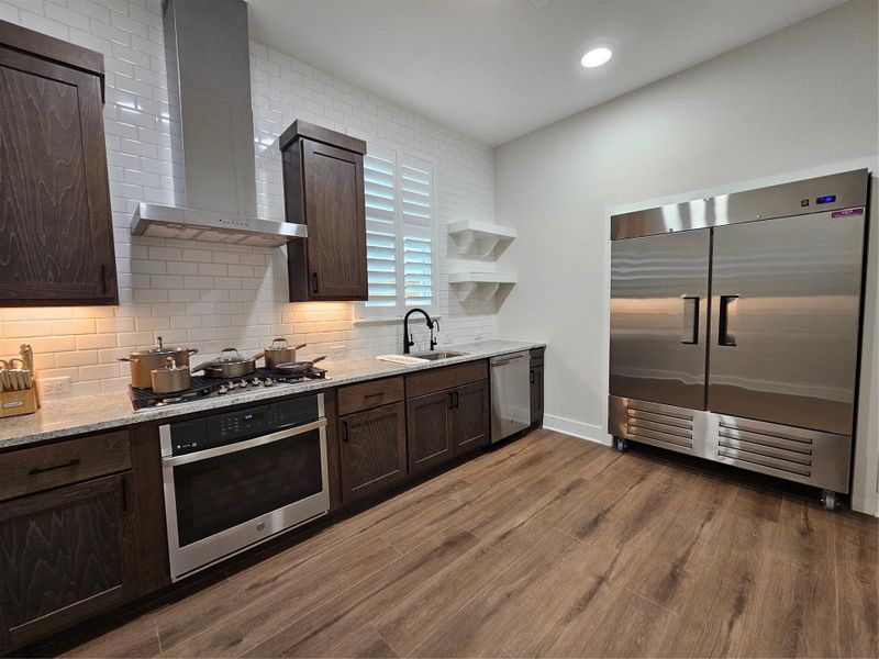 Explore the convenience of a second kitchen featuring a spacious industrial refrigerator, perfect for entertaining and additional storage needs. Explore the convenience of a second kitchen featuring a spacious industrial refrigerator, perfect for entertaining and additional storage needs.