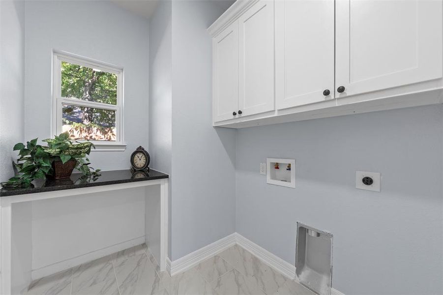 Washroom with light marble finish floors, washer hookup, cabinet space, and electric dryer hookup