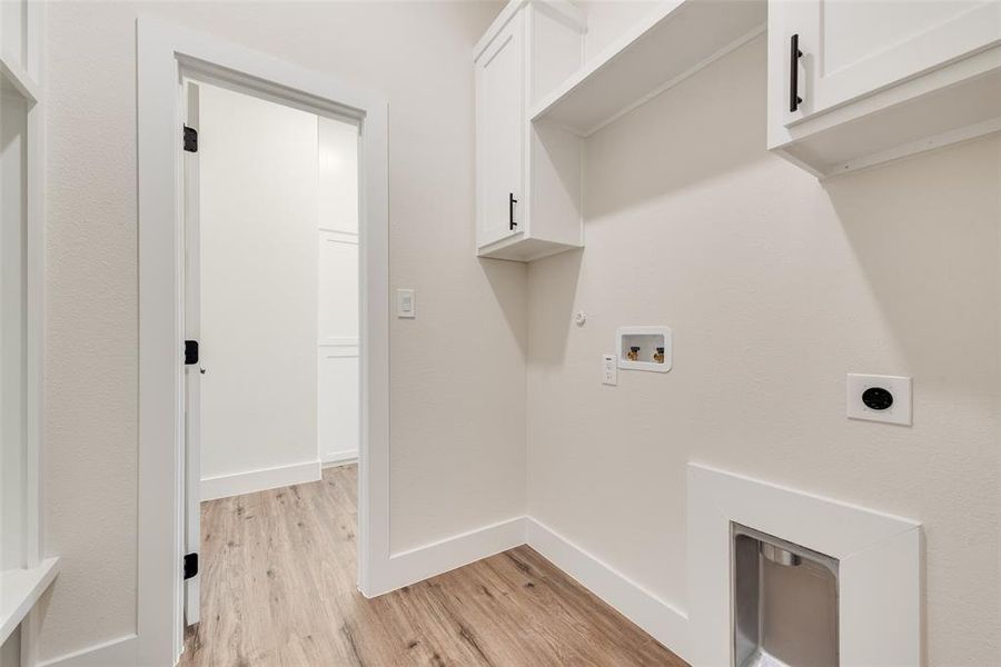 Laundry room featuring light wood-style flooring, hookup for an electric dryer, cabinet space, hookup for a gas dryer, and hookup for a washing machine