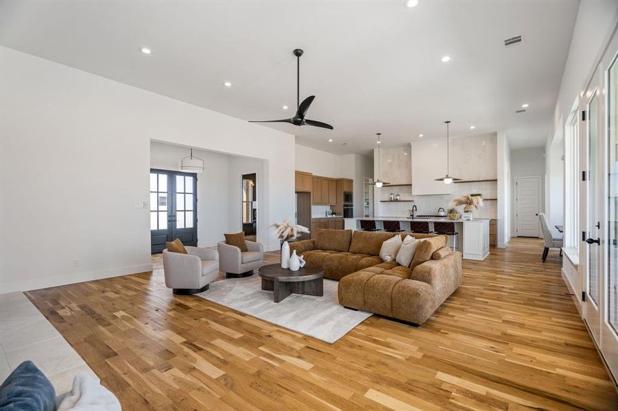 Living room featuring ceiling fan, sink, light hardwood / wood-style floors, and french doors