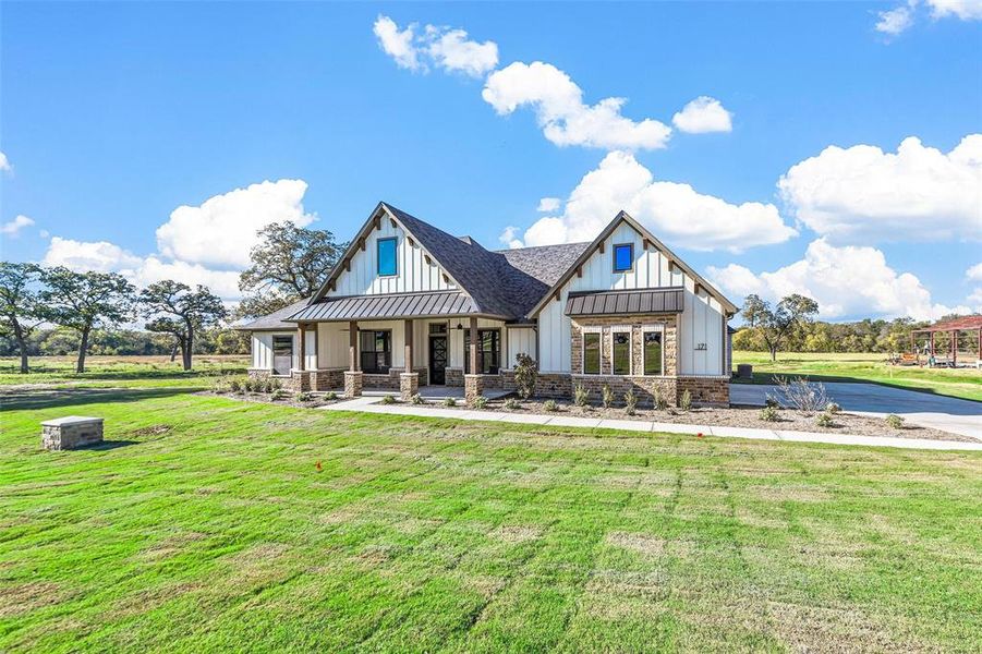 Rear view of property featuring a lawn and a porch