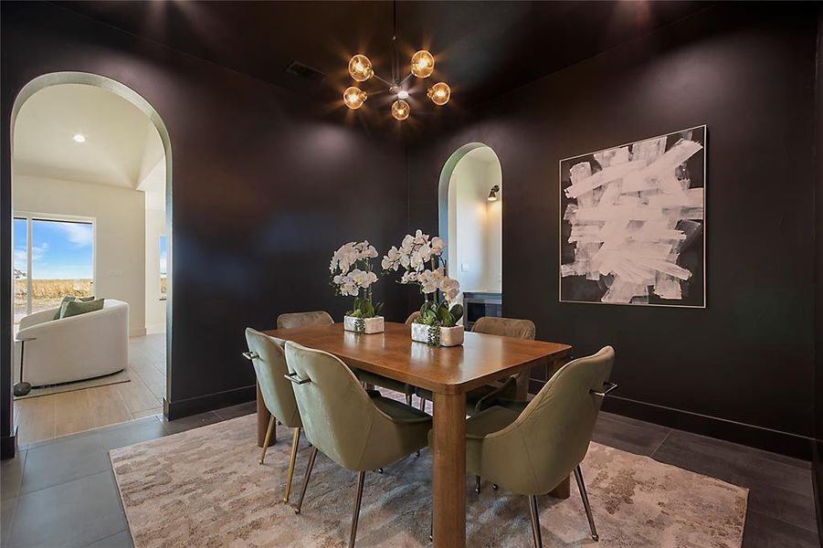Dining space featuring arched walkways and a chandelier Dining space featuring arched walkways and a chandelier