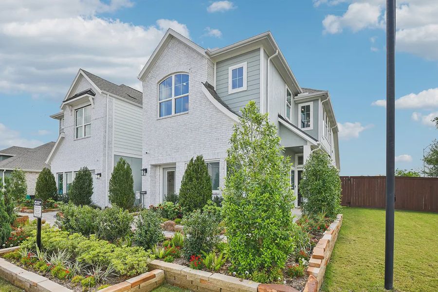 Front exterior of a new home in Meridiana Chateau, Manvel, TX, highlighting curb appeal (Image 22).