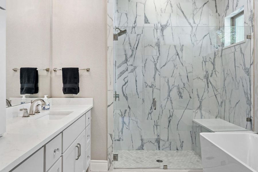 Designer lighting and elegant hardware elevate the primary bathroom beautifully. Designer lighting and elegant hardware elevate the primary bathroom beautifully.