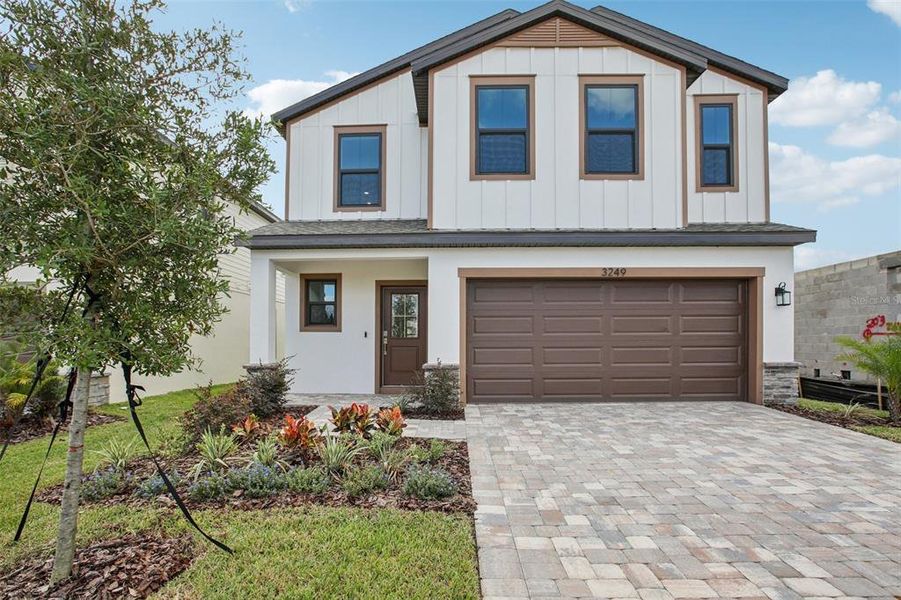 Front exterior of a new home in Grasslands West, Lakeland, FL, highlighting curb appeal (Image 1).