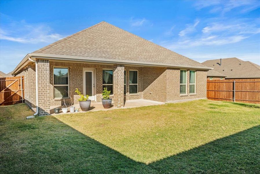 Rear view of house with a yard and a patio area