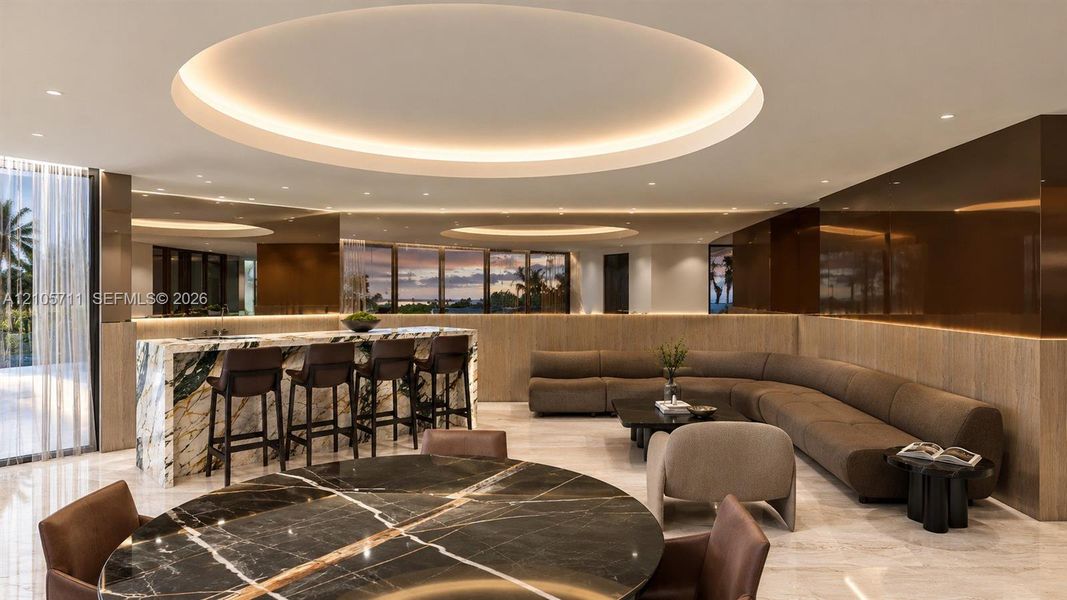 Expansive living area featuring circular recessed ceiling detailing, stone-topped bar island with integrated sink, floor-to-ceiling mirror panels, high-gloss wall cladding, and stone flooring throughout