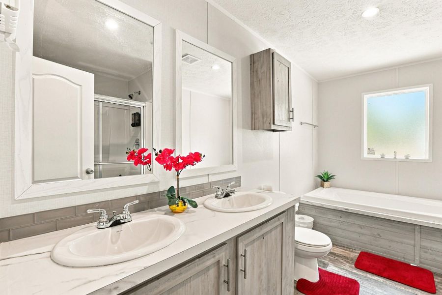 A spacious double vanity and a deep soaking tub anchor this modern bathroom design.
