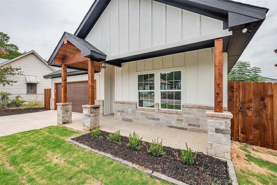 View of front of property featuring a garage and a front lawn