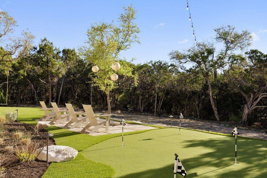 Surrounding community featuring an area to practice putting and a patio area