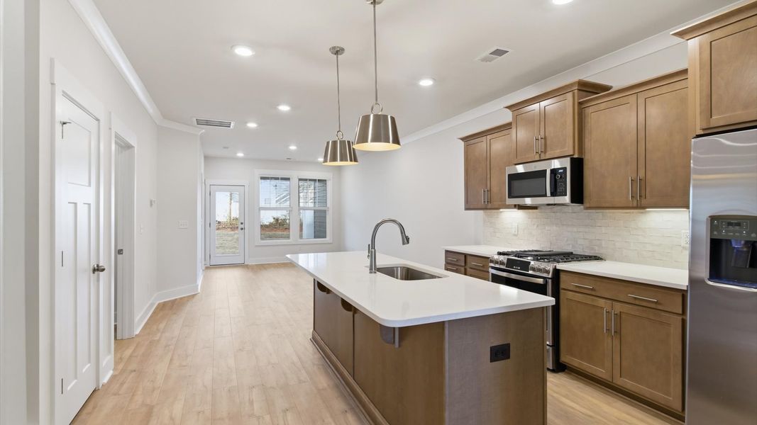 Tasteful kitchen with a streamlined island and modern finishes in a first-class DRB Homes design at Pelham Crossing